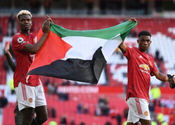 PAUL Pogba (kiri) dan Diallo memegang bendera Palestin ketika mengelilingi padang selepas tamat perlawanan. FOTO AFP