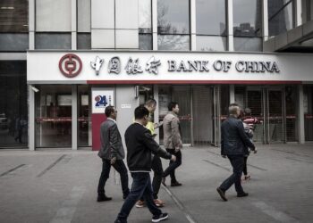 BEBERAPA lelaki berjalan melepasi cawangan Bank of China di Chengdu.-AGENSI