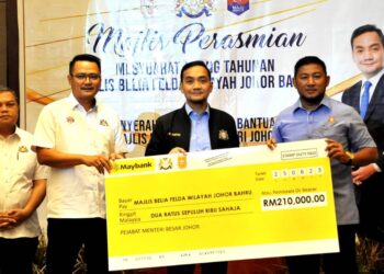 ONN HAFIZ GHAZI menyampaikan geran bernilai RM210,000 kepada Muhammad Fadzli Hasan (kanan) sambil diperhatikan oleh Mohd. Hairi Mad Shah  pada Mesyuarat Agung Tahunan Majlis Belia Felda Wilayah Johor Bahru & Penyerahan Sumbangan Bantuan Majlis Belia Felda Negeri Johor di Hotel Amari, Johor Bahru.