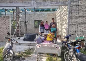 MOHAMAD Zulkarnain Mustafa (depan) bersama ibu bapa dan adik-beradiknya di hadapan bengkel motosikalnya yang terbengkalai di Chenderong Balai dekat Pasir Salak, Perak. 