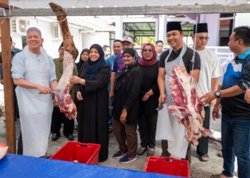 FADILLAH Yusof (kiri) memotong daging lembu di Majlis Ibadah Korban Wanita Cawangan N6 Tupong di Surau Darul Fadzillah, Gita Laut, Kuching.