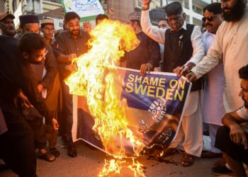 PENDUDUK Pakistan di Karachi membakar bendera Sweden sebagai protes terhadap tindakan membakar al-Quran oleh seorang aktivis di luar masjid di Stockholm. - AFP