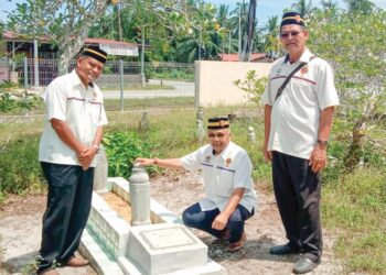 SHARUDDIN Omar (tengah) menziarahi kubur anggota Renjer Mohd. Desa Mohd. Hasyim yang terkorban dalam pertempuran di Sarawak pada 11 Oktober 1973 di Tanah Perkuburan Islam Kampung Panchor, Pantai Remis, Perak, baru-baru ini. - UTUSAN/SHAMSUL KAMAL AMARUDIN