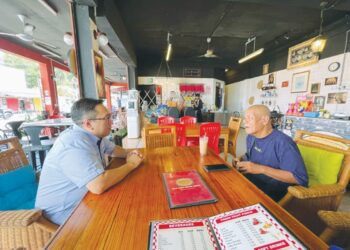 SHAHRUL MIZAN Ismail (kiri) mengadakan perbincangan dengan Ross Ariffin di Restoran Sangkeriau, Jalan Hang Tuah, Melaka. - UTUSAN/AMRAN MULUP