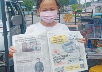 LUA Mek menunjukkan akhbar Utusan Malaysia yang dibelinya di bandar Jerantut, Pahang. - UTUSAN/HARIS FADILAH AHMAD