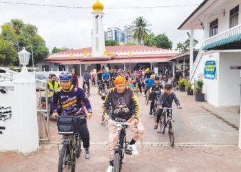 IMAM muda Masjid Pintu Geng, Mohammad Saifullah Yusoff (kiri) mengetuai seramai 60 peserta Kayuhan Maal Hijrah Masjid Mukim Pintu Geng mengelilingi kawasan kampung bagi meraikan sambutan Maal Hijrah 1445H. – UTUSAN/MUSTAQIM MOHAMED