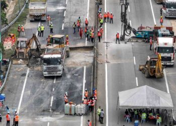 KERJA-kerja menutup lubang mendapan giat dijalankan di Kilometer 66.1  Lebuhraya Kuala Lumpur-Karak berdekatan Plaza Tol Bentong, Pahang, semalam. – UTUSAN/AMIR KHALID