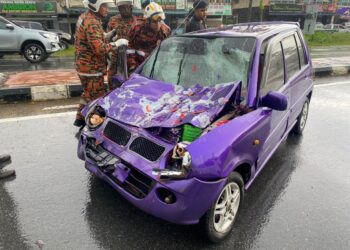 ANGGOTA bomba mengeluarkan Mohd. Maznizam dari dalam kereta Perodua Kancil yang bertembung dengan sebuah lori di Kilometer 58.5, Jalan Batu Pahat-Mersing.