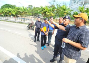 MOHAMAD FAZLI MOHAMAD SALLEH  (kanan) bersama Raub Selamat  meninjau keadaan trafik di Lebuhraya Penyuraian Timur, Johor Bahru.