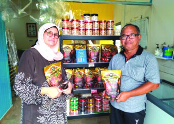 NORA Ashah Ibrahim (kiri) dan Ahmad Rosly Abdul Aziz menunjukkan antara produk Rendang Tok Yoep di kilang masakan di Talang, Kuala Kangsar. – UTUSAN/FADZIL ZAINOL