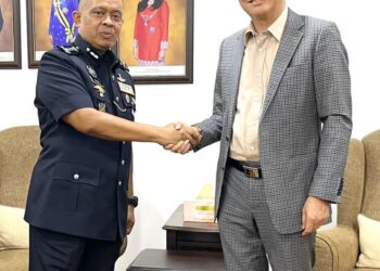 TEE SIEW KIONG (kanan) bersalaman dengan Kamarul Zaman di IPK Johor, Johor Bahru.