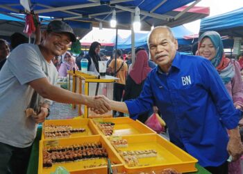 JAHAYA Ibrahim menyantuni peniaga-peniaga Pasar Malam Bukit Kuching di Jeram, Kuala Selangor, semalam.