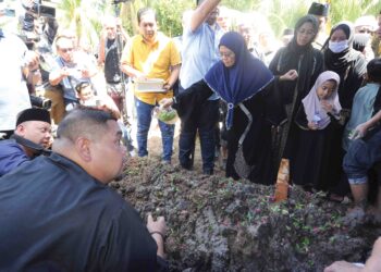 BALU Allahyarham Salahuddin Ayub, Datin Seri Fatimah Taha menyiram air mawar ke atas pusara suaminya di Tanah Perkuburan Islam, Serkat, Pontian, Johor, semalam. – UTUSAN/RAJA JAAFAR ALI