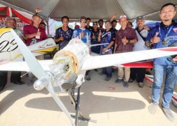 Muhamad Zamri Ibrahim (tiga dari kanan) bersama sebahagian pemilik pesawat mainan di Kampung Gong Kubur, Pasir Puteh, Kelantan, semalam. UTUSAN/TOREK SULONG