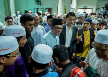 Anwar Ibrahim bersalaman bersama para jemaah ketika tiba untuk menunaikan solat Jumaat di Masjid Al-Khairiyah, Taman Sri Gombak semalam. -UTUSAN/ FARIZ RUSADIO