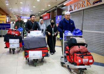 SEBAHAGIAN daripada jemaah haji yang menaiki penerbangan pertama selamat tiba di Lapangan Terbang Sultan Ismail Petra, Pengkalan Chepa, Kota Bharu, Kelantan awal pagi tadi-UTUSAN/KAMARUL BISMI KAMARULZAMAN