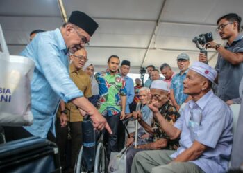 ANWAR Ibrahim menyantuni penerima bantuan pada Majlis Ramah Mesra Perdana Menteri bersama Masyarakat Daerah Kubang Pasu di tapak pembinaan Masjid Changlun.- UTUSAN/ SHAHIR NOORDIN