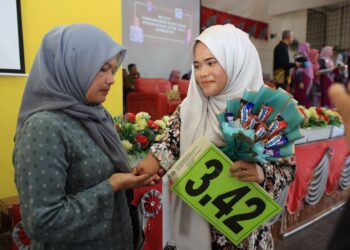 ROORIDA Duerorman menunjukkan tangan kanan anaknya Nurulain Natasya Marzuki semasa majlis pengumuman keputusan STPM di SMK Pengkalan Chepa, Kota Bharu, Kelantan hari ini-UTUSAN/KAMARUL BISMI KAMARULZAMAN