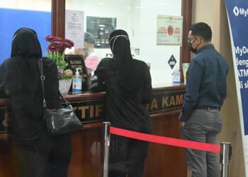 OKS (kanan) membayar denda selepas didapati bersalah oleh Mahkamah Majistret, Ayer Keroh, Melaka kerana memanipulasi harga produk kesihatan. - UTUSAN/MUHAMMAD SHAHIZAM TAZALI