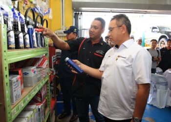 NIK MOHD. Fahizul Nik Mohamad (kiri) memberi penerangan kepada Adly Zahari (kanan) yang turun padang meninjau bengkel kenderaan miliknya menerusi Program Peduli ATM peringkat Negeri Kelantan di Kampung Bechah Kura, Melor, Kelantan.-UTUSAN/KAMRUL BISMI KAMARUZAMAN