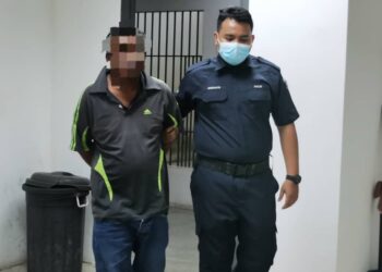 TERTUDUH (kiri) diiringi polis semasa menghadiri perbicaraan didakwa di Mahkamah Majistret Kota Bharu, Kelantan-UTUSAN/ROSALWANI CHE SOH