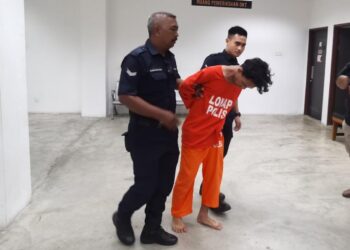 SUSPEK (tengah) dibawa polis untuk mendapatkan perintah reman selepas membuat laporan polis palsu di Mahkamah Majistret Kota Bharu, Kelantan hari ini-UTUSAN/ROSALWANI CHE SOH