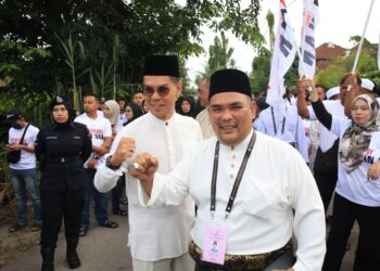 SUZAINAL Adnan Sukri (kanan) bersama Fauzi Nawawi yang turut hadir memberikan sokongan kepadanya semasa proses penamaan calon bagi DUN Tendong di Dewan Kolej Vokasional Pasir Mas, Bunut Susu, Pasir Mas, Kelantan hari ini-UTUSAN/KAMARUL BISMI KAMARUZAMAN