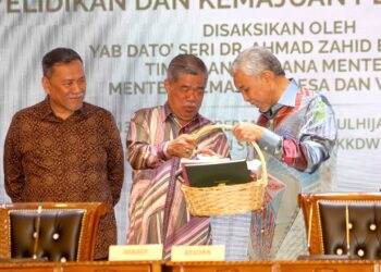 AHMAD Zahid Hamidi menerima cenderamata daripada Mohamad Sabu selepas majlis menandatangani MoU antara KEJORA dan MARDI di Putrajaya, semalam. – UTUSAN/FAISOL MUSTAFA