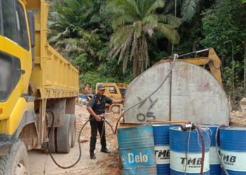 PEGAWAI penguat kuasa KPDN Manjung memeriksa lori yang disyaki digunakan untuk menyeleweng diesel bersubsidi dalam serbuan di sebuah setor di Trong dekat Beruas semalam. - UTUSAN/IHSAN KPDN PERAK