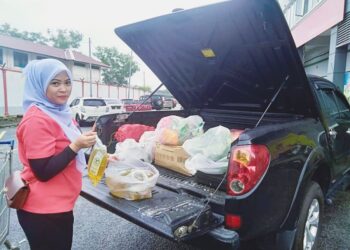 DANG Merduwani Tajuddin menunjukkan minyak masak peket yang dibelinya di sebuah pasar mini di Sungai Petani, Kedah. - UTUSAN/ OTHMAN YAHAYA