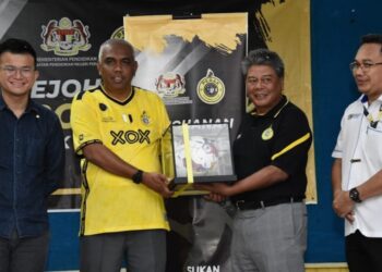 KHAIRUDDIN Abu Hanipah (dua dari kiri) menerima cenderahati daripada Abdul Azim Mohd. Zabidi pada pelancaran kejohanan Piala Cheetah di padang SYS Batu Gajah, semalam. - UTUSAN