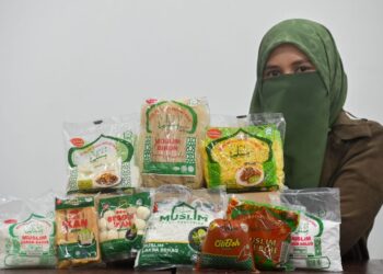 JAMEELAH Jamaludin menunjukkan sebahagian daripada produk keluaran Muslim Food Industries di Kuala Terengganu, baru-baru ini. - UTUSAN/PUQTRA HAIRRY ROSLI