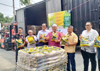 WAN Sukairi Wan Abdullah (tiga dari kanan) menunjukkan beras jenama Ganu di Pasar Raya Ameen Hallmart di Kampung Losong, Kuala Terengganu, hari ini. - UTUSAN/KAMALIZA KAMARUDDIN