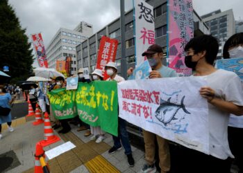 PENUNJUK perasaan memegang sepanduk membantah tindakan melepaskan sisa air di loji nuklear Fukushima dalam protes di Tokyo, baru-baru ini. - AFP