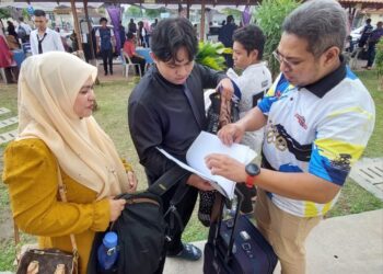 MOHAMAD YUSRI Kamaruddin (kanan) dan isterinya membantu Mohamad Syabil Wafiy (berbaju hitam) menyusun dokumen ketika hadir pada sesi pendaftaran pelajar baharu PSP untuk semester 1, 2023/2024, di Permatang Pauh, Pulau Pinang, semalam.