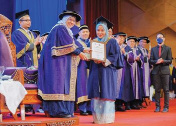 ROZIAH Mohd. Janor menyerahkan Sijil Khas Penganugerahan kepada Nur Liyana Athirah Izani yang menerima skrol ke satu juta pada Istiadat Konvokesyen UiTM Ke-97 di Dewan Agong Tuanku Canselor di UiTM Shah Alam, Selangor. - UTUSAN/FARIZ RUSADIO