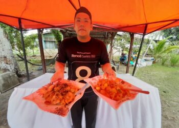 FIRDAUS Emir Chan Abdullah menunjukkan antara menu yang dijual di gerainya di Kampung Mersing Kanan, Mersing, Johor.