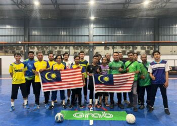 PEMAIN Persatuan Wartawan Perlis (PWP) dan GrabFood bergambar bersama Jalur Gemilang sebelum perlawanan futsal merdeka di Arena Futsal UTC, Kangar, Perlis baru-baru ini. – UTUSAN/MOHD. HAFIZ ABD. MUTALIB