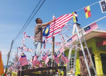 SALAH seorang penduduk menghias rumahnya dengan Jalur Gemilang sempena sambutan Hari Kebangsaan Ke-66 di Felda Kerteh 6, Dungun, Terengganu. - UTUSAN/NIK NUR IZZATUL HAZWANI NIK ADNAN