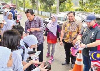 NAJWAN Halimi (dua dari kiri) memberikan Jalur Gemilang kepada beberapa murid SK Seksyen 6, Shah Alam, Selangor baru-baru ini. – UTUSAN/MOHAMAD NAUFAL MOHAMAD IDRIS