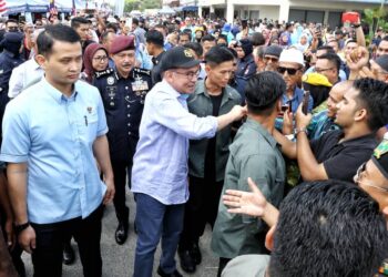 ANWAR Ibrahim disambut rakyat pada program Sentuhan Agro Madani Peringkat Negeri Perak di Dataran Kerian Permai di Parit Buntar hari ini. - UTUSAN/MUHAMAD NAZREEN SYAH MUSTHAFA