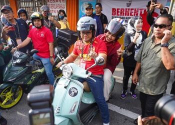 AMIRUDIN Shari bersama isteri, Masdiana Muhamad menaiki motosikal Vespa selepas selesai mengundi di Sekolah Jenis Kebangsaan Cina (SJKC) Selayang Baru bagi kerusi Dewan Undangan Negeri (DUN) Taman Templer. - UTUSAN/SHIDDIEQIIN ZON