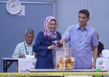 MOHAMED Azmin Ali bersama isterinya, Datin Seri Shamsida Taharin membuang undi di Sekolah Kebangsaan Klang Gate, Hulu Kelang, pagi ini. - UTUSAN/FAUZI BAHARUDIN