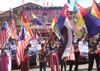 M. KANDAPAN (tengah) bersama-sama ahli keluarganya mengibarkan Jalur Gemilang serta bendera kesemua negeri sempena sambutan Hari Kebangsaan tahun ini.