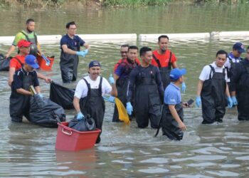 MOHD. JAFNI  MD. SHUKOR (hadapan, kiri} an Onn Hafiz (dua kanan) meredah sungai untuk mengutip sampah pada Program Pembersihan Sungai Skudai di Taman Impian Emas, Johor Bahru.