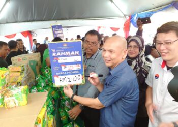 ARMIZAN MOHD. ALI (tengah) menetapkan harga jualan beberapa produk sempena program Jualan Rahmah Mega di pekarangan Stadium Tertutup MBPG, Johor Bahru.