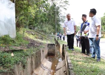 MOHD. JAFNI MD. SHUKOR (kiri) mengadakan lawatan ke kawasan Tampoi Indah di Parlimen Pulai yang sering dilanda banjir kilat.