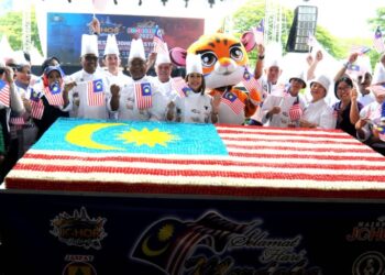 PANDAK AHMAD (tengah) dan Suhairi Hashim bersama-sama chef meraikan Kek Vegetarian Jalur Gemilang terbesar berukuran 9x5 kaki yang berjaya dimasukkan dalam MBOR sempena Festival Majestic Johor 2023 di Iskandar Puteri.