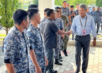 MOHAMAD Hasan bersalaman dengan anggota dan pegawai TUDM ketika meninjau proses pengundian awal di Dewan Angkasaraya, Pangkalan Udara Sendayan, Seremban hari ini.-UTUSAN/ZAKKINA WATI AHMAD TARMIZI.