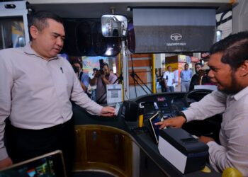 ANTHONY Loke Siew Fook melihat inisiatif penggunaan kad myBas Konsesi selepas mengumumkan inisiatif Tambang Percuma myBas Konsesi Bagi Perkhidmatan Bas Berhenti-Henti Program SBST di Terminal 1, Seremban hari ini.-UTUSAN/MOHD. SHAHJEHAN MAAMIN.